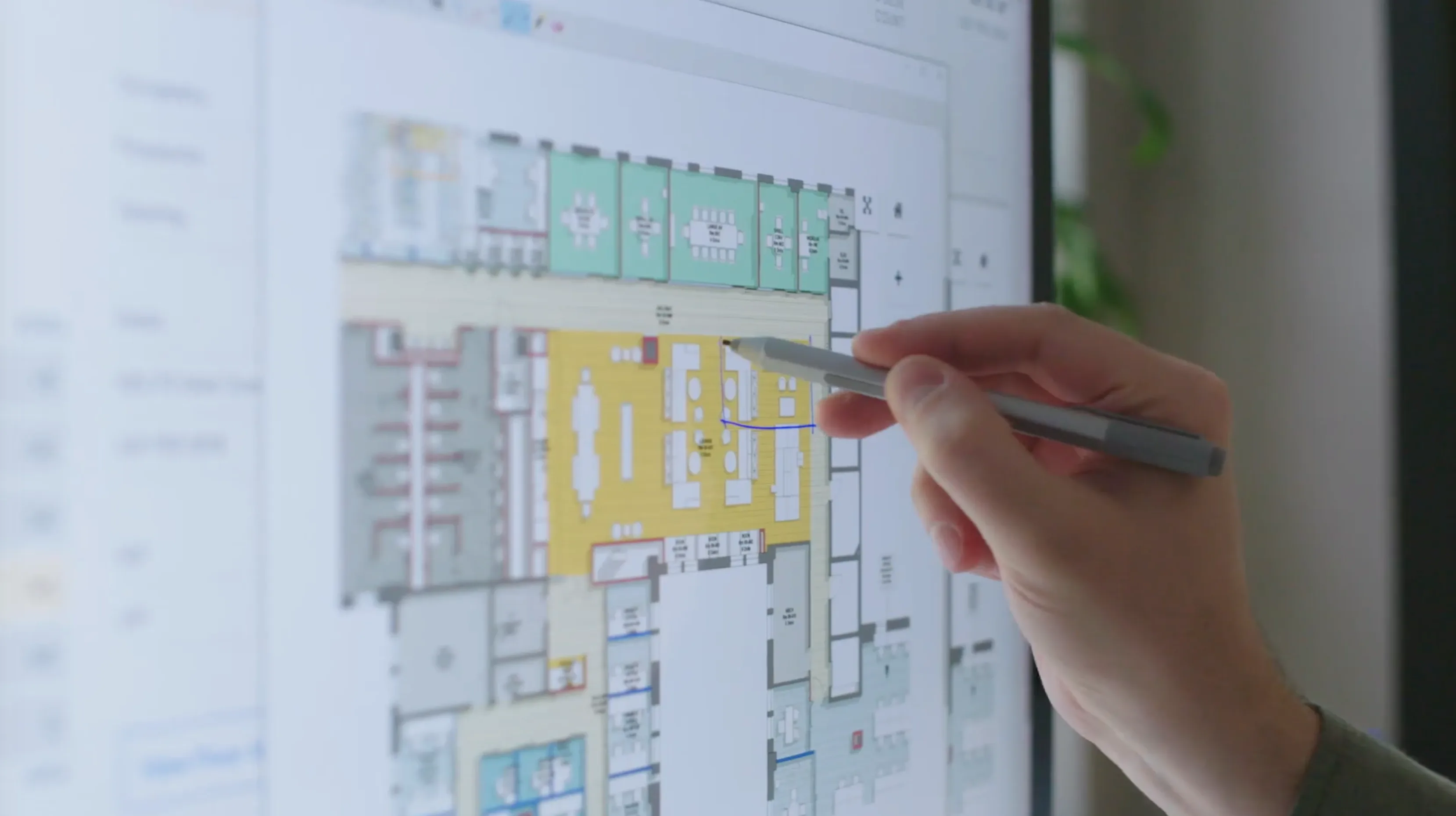 Designer annotating a colored floor plan on a touch screen